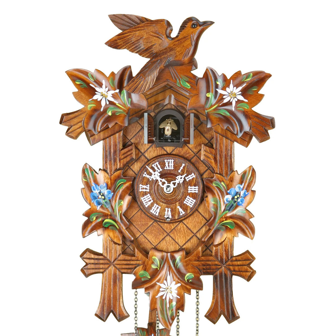 Close up of wooden cuckoo clock with decorative elements on a white background
