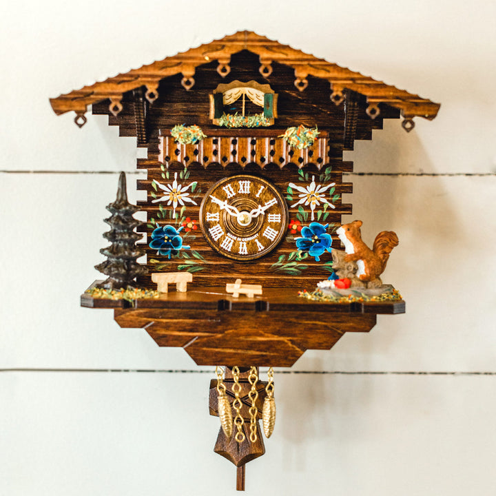 Wooden cuckoo clock with decorative elements on a white background