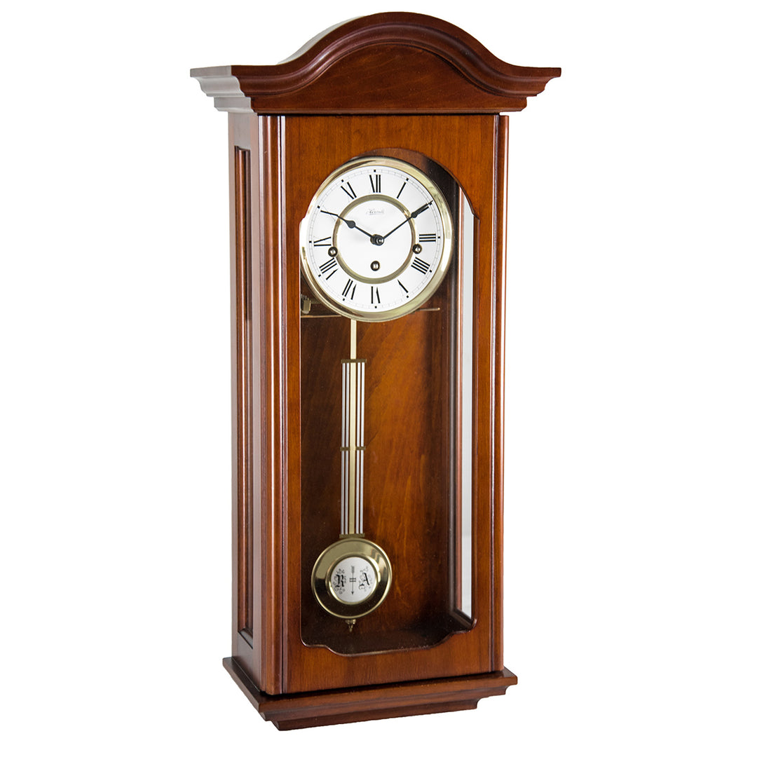 Wooden wall clock with pendulum on a white background