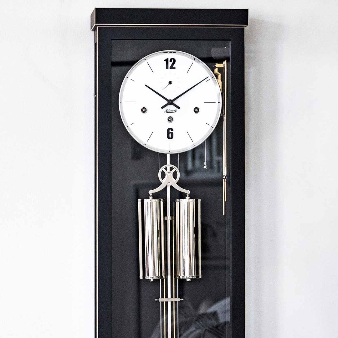 Close up black wall clock with white face and silver trim