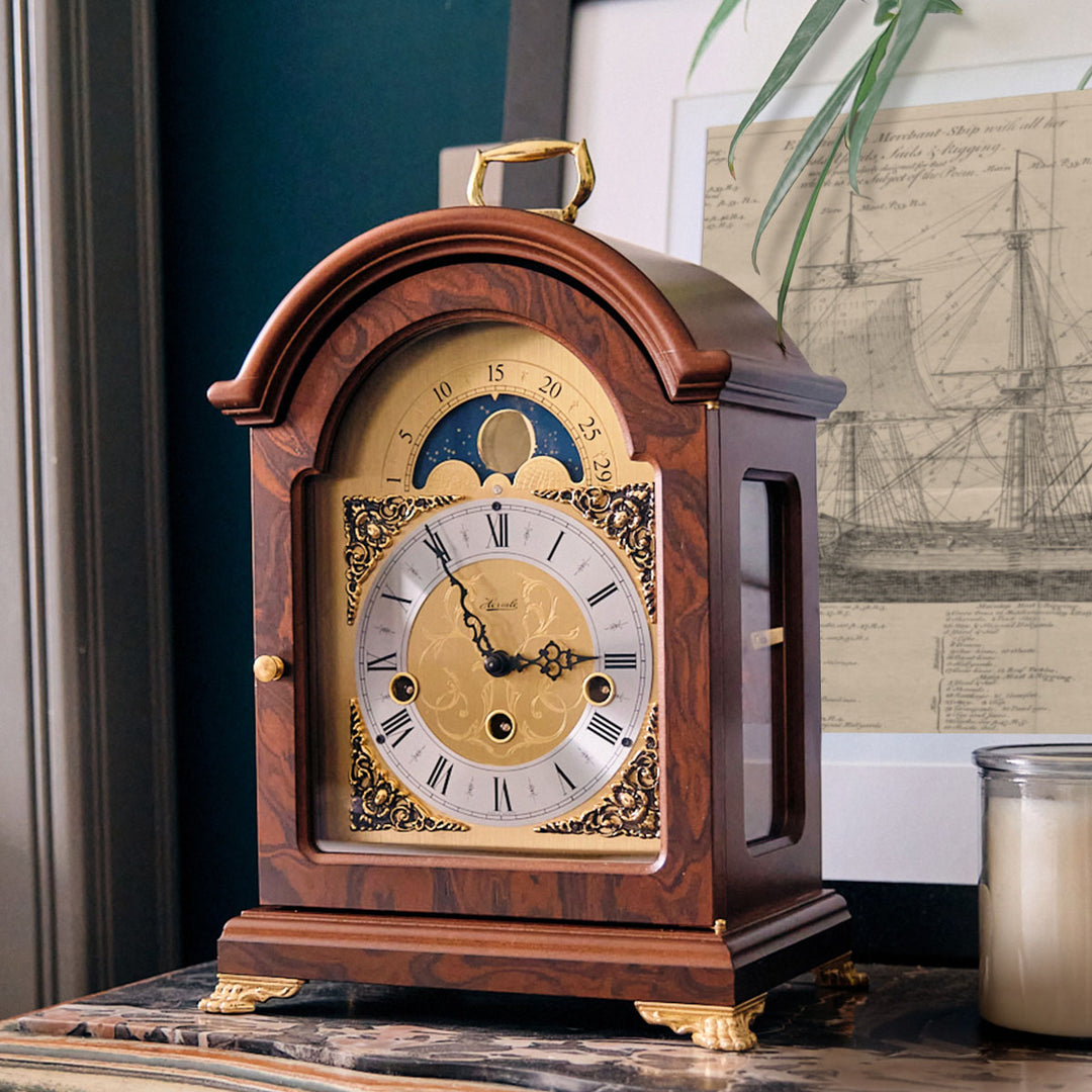 Decorative clock on marble dresser with blueprint of boat behind