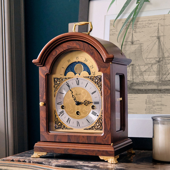 Decorative clock on marble dresser with blueprint of boat behind