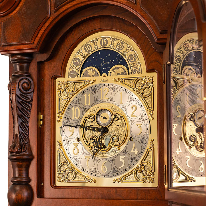 Close-up of brass clock face with carved details on cherry wood grandfather clock.
