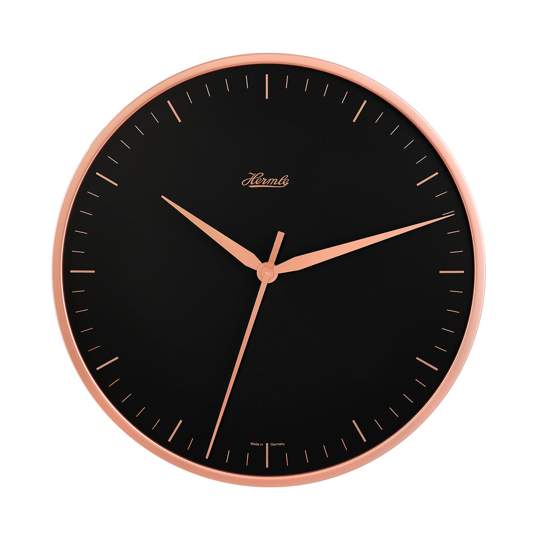 Wall clock with rose gold highlights and black face on white background.