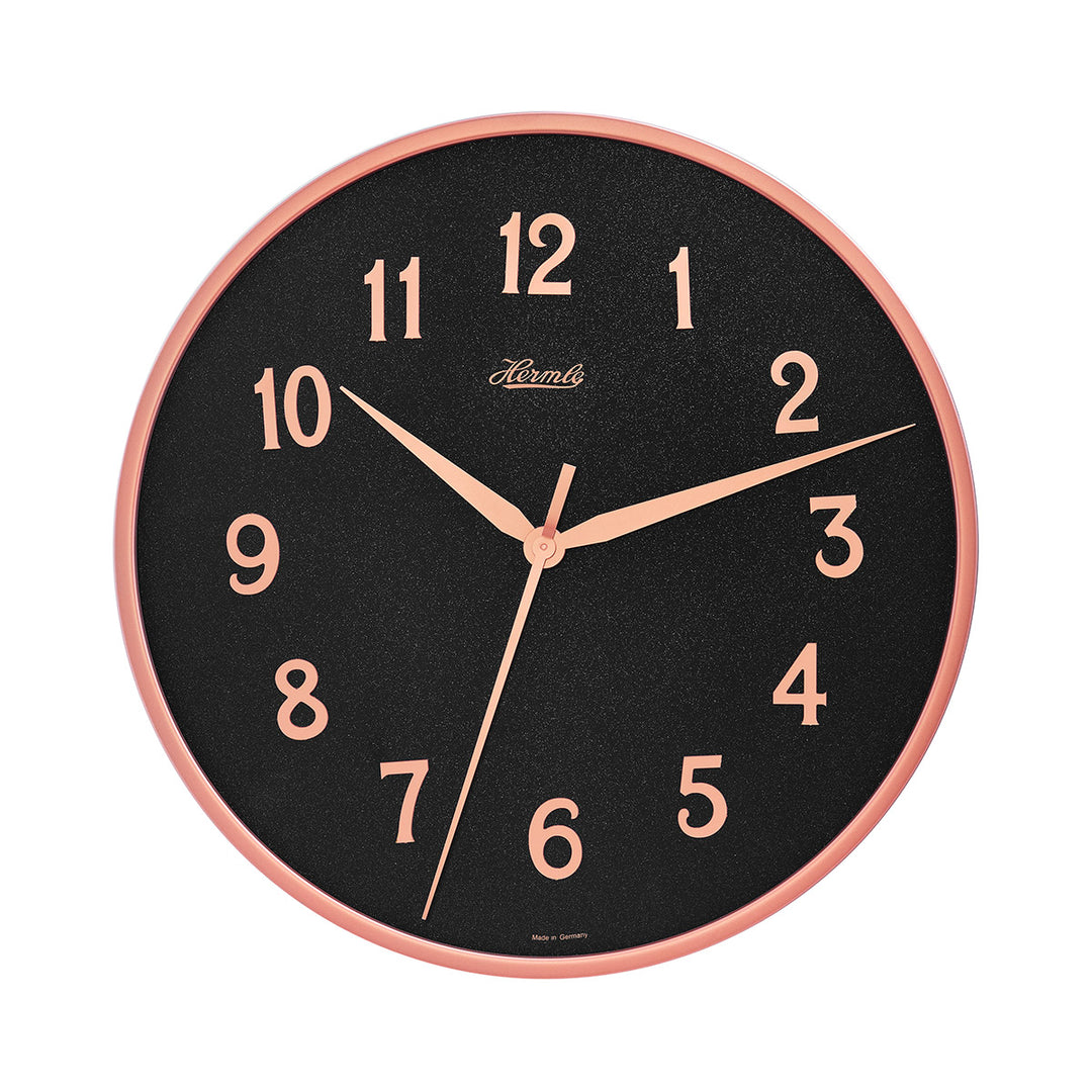 Wall clock with rose gold highlights and black face with Hermle logo on white background.