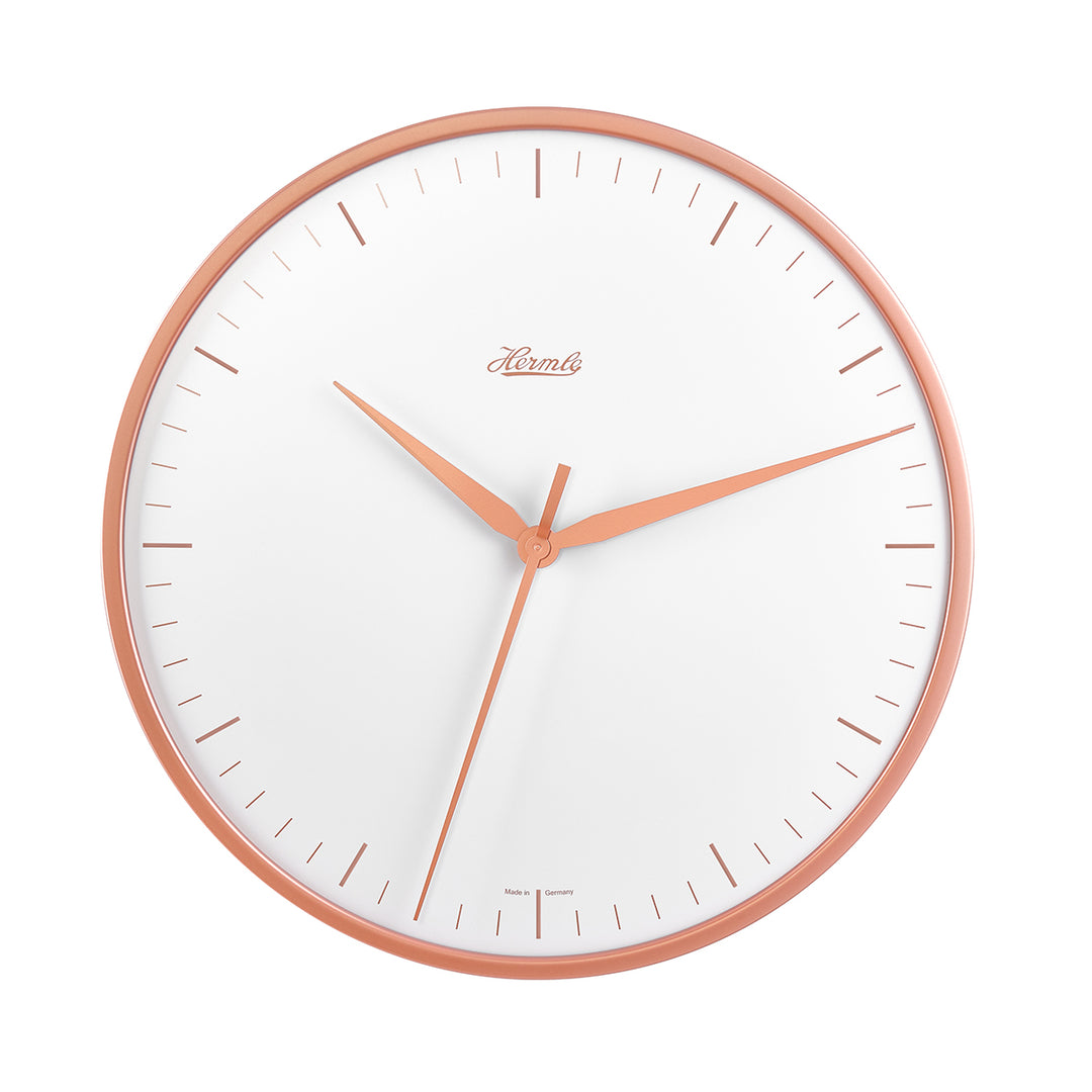 Wall clock with rose gold highlights and white face on white background.