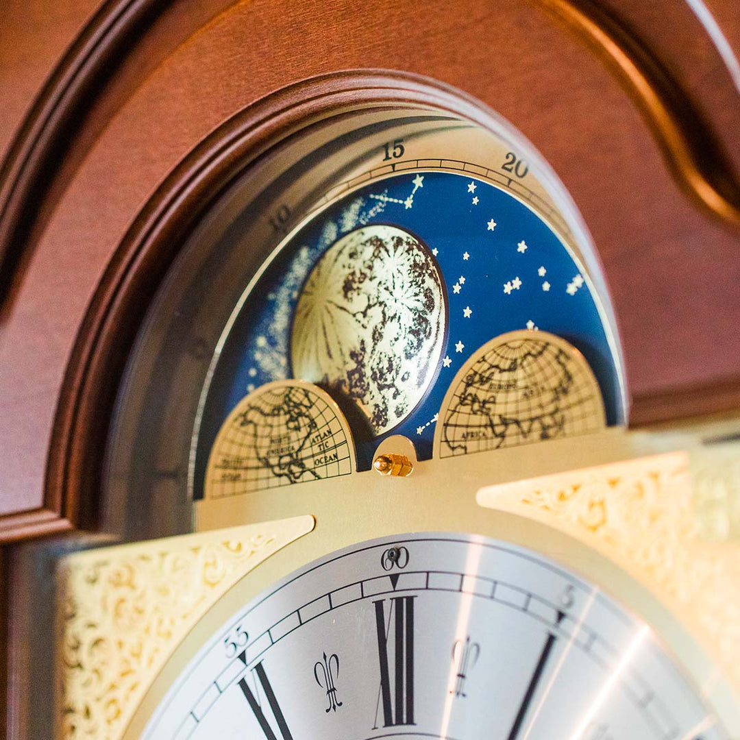 Close up moon phase dial on wooden grandfather clock with brass face 
