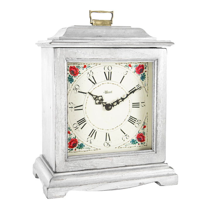 White decorative clock with floral design and roman numerals on a white background