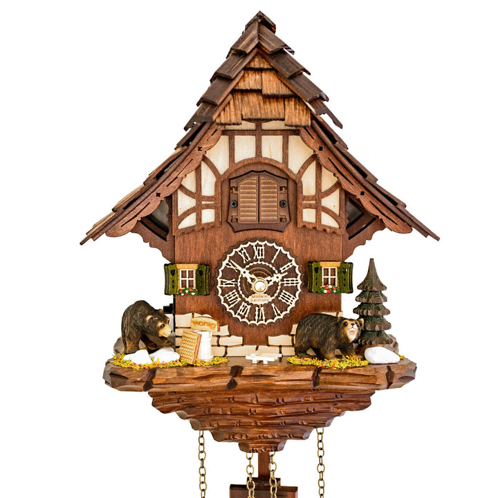 Close up of wooden cuckoo clock with 'Made in Germany' on the face and green shutters alongside.