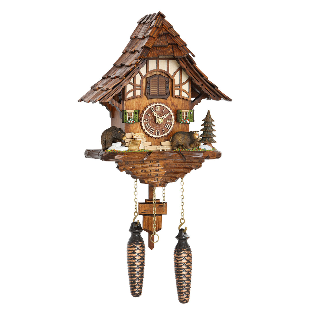 Ornate wooden cuckoo clock with bear figurines and pine tree on white background.