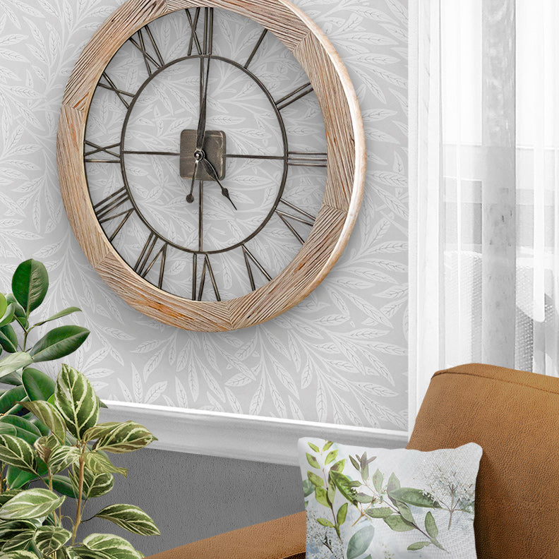 Farmhouse style round wood and metal wall clock by Hermle in living room scene with plants and sofa. 