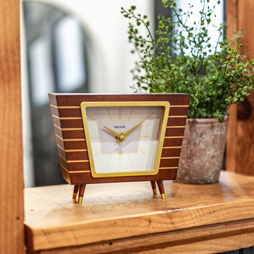 Retro style wooden clock on wood shelf in living room.