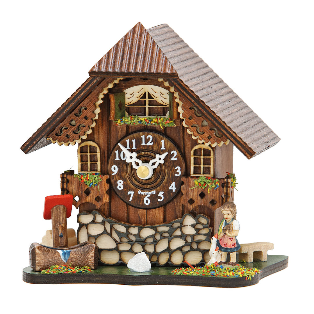 Small wooden cuckoo clock with girl figurine and Arabic numerals on white background.