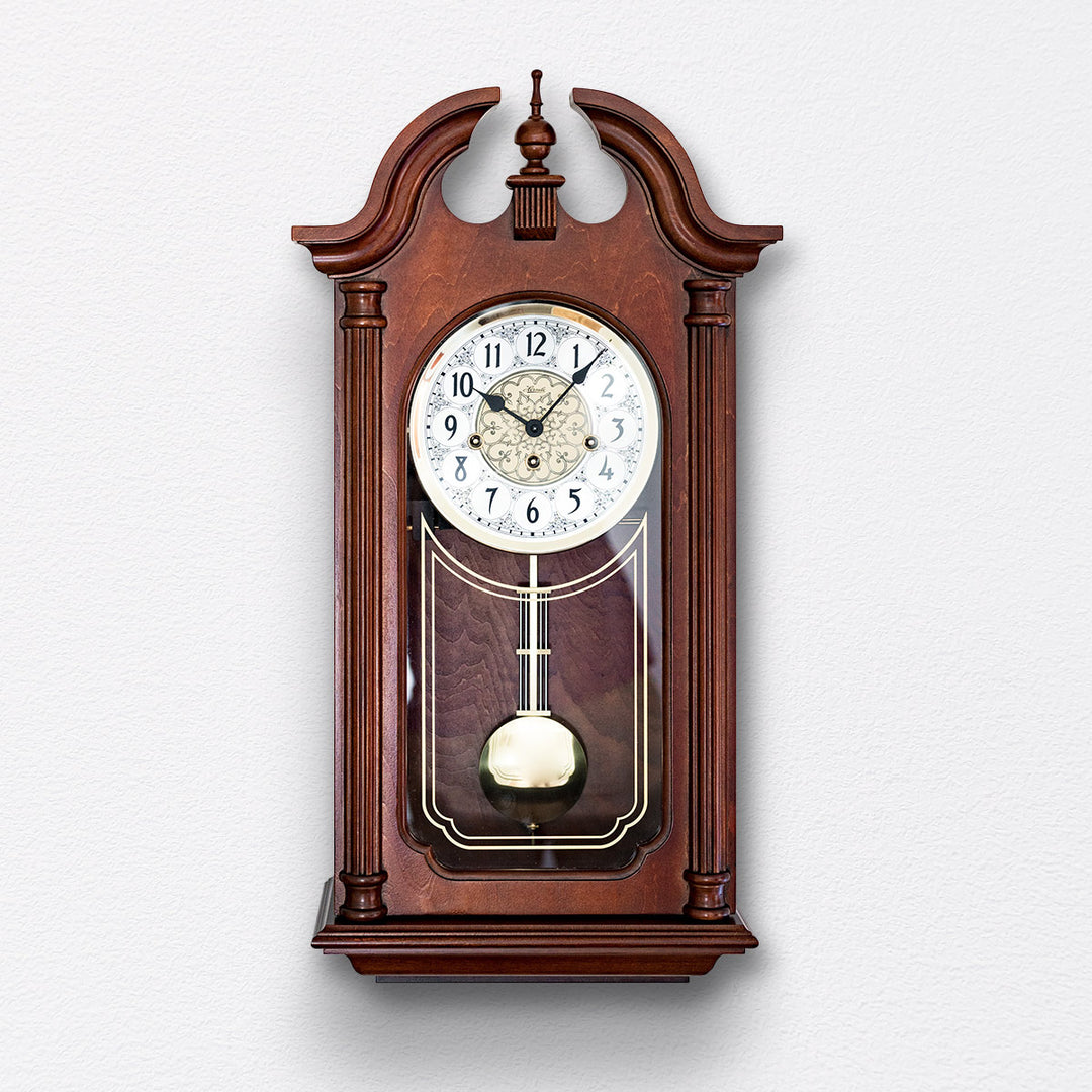 Front view of Hopewell wooden vintage style wall clock by Hermle on white wall.