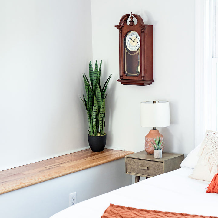 Hopewell wooden vintage style wall clock by Hermle in bedroom scene.