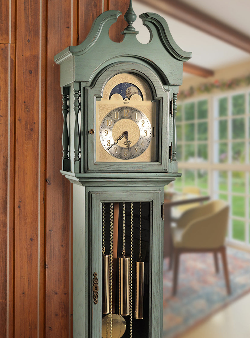 Stylish grandfather clock by wooden wall and dining room scene. Heirloom clock by Hermle.
