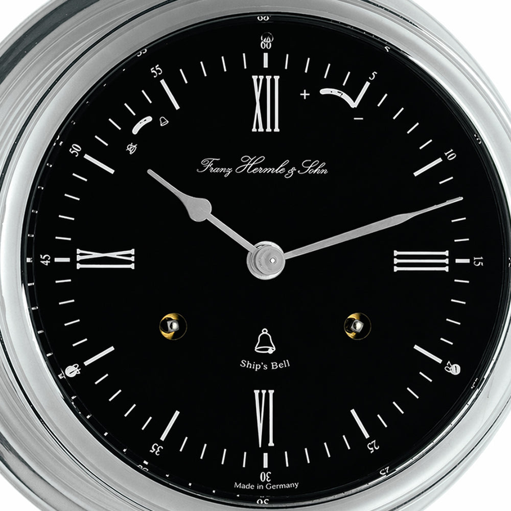 Classic ship's bell clock in nickel with black dial, by Hermle - closeup of clock dial.