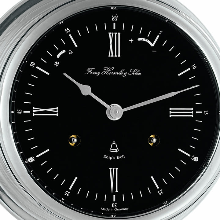 Classic ship's bell clock in nickel with black dial, by Hermle - closeup of clock dial.