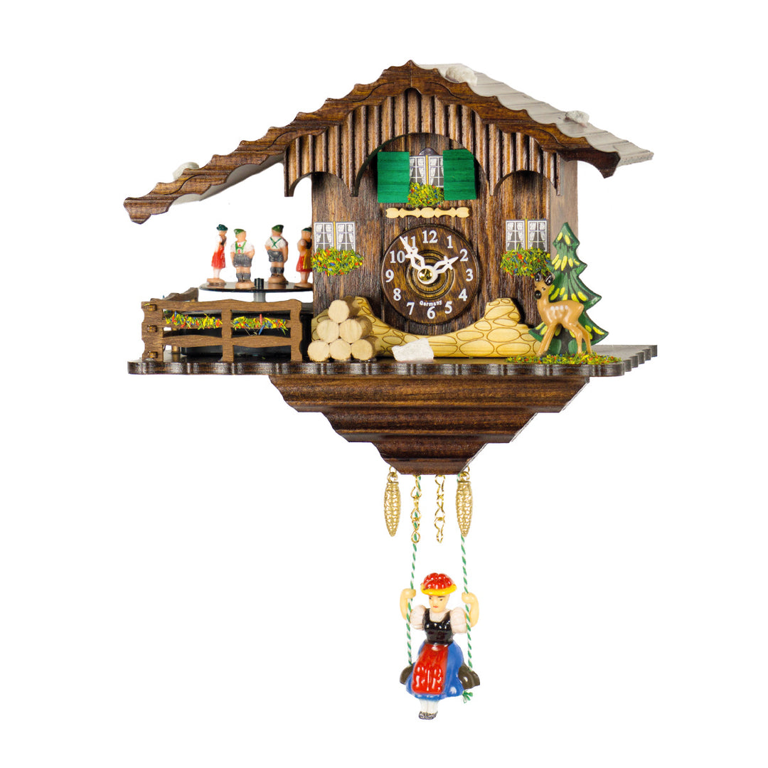 Ornate wooden cuckoo clock with pine tree and girl on swing figurines on white background.