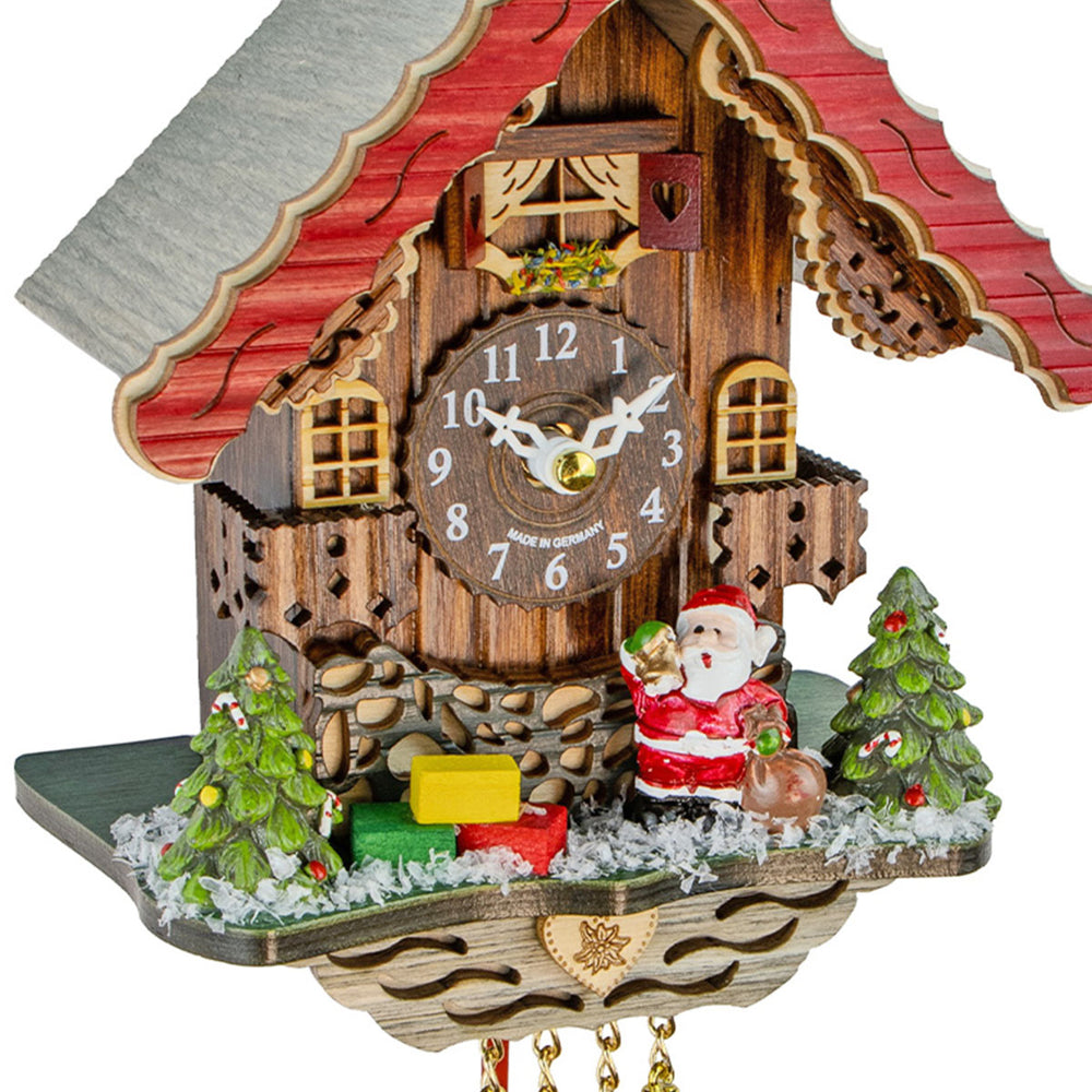 Close-up of Christmas themed wooden cuckoo clock with Santa Claus and Christmas trees.