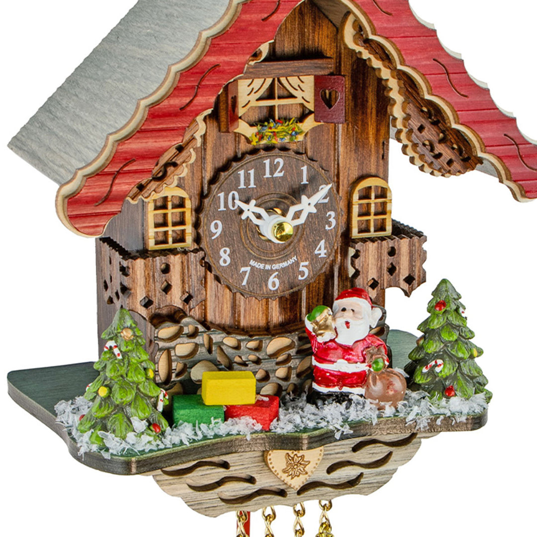 Close-up of Christmas themed wooden cuckoo clock with Santa Claus and Christmas trees.
