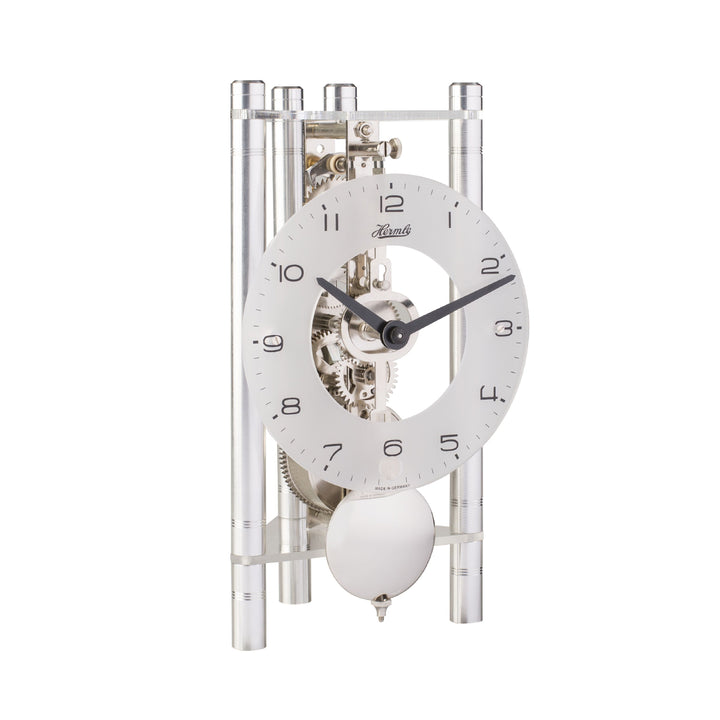 Silver mechanical clock with glass face and intricate gears visible on white background
