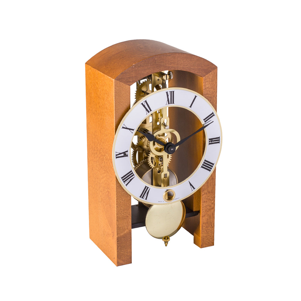 Mechanical clock with light cherry casing and silver face highlighted by brass on a white background