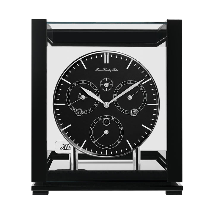 Front view of black perpetual calendar clock with black face, silver hands and glass panels on white background.