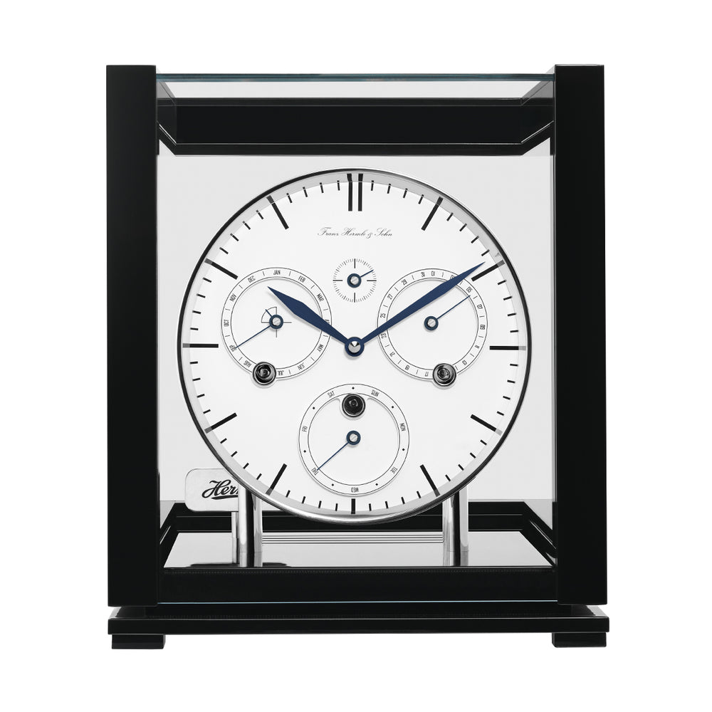Front view of black perpetual calendar clock with white face and silver highlights on white background.
