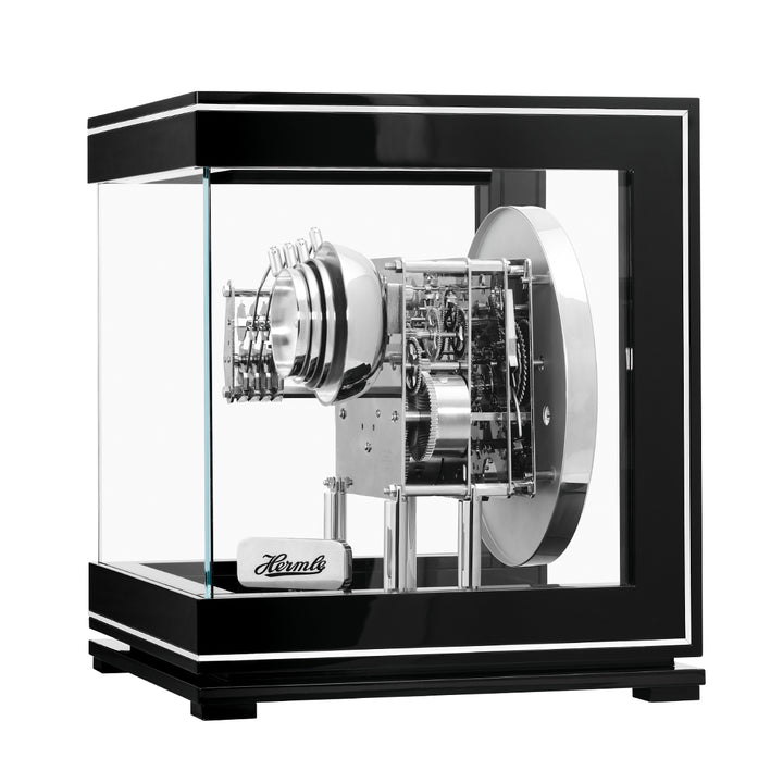 Intricate gears inside black and silver perpetual calendar clock.