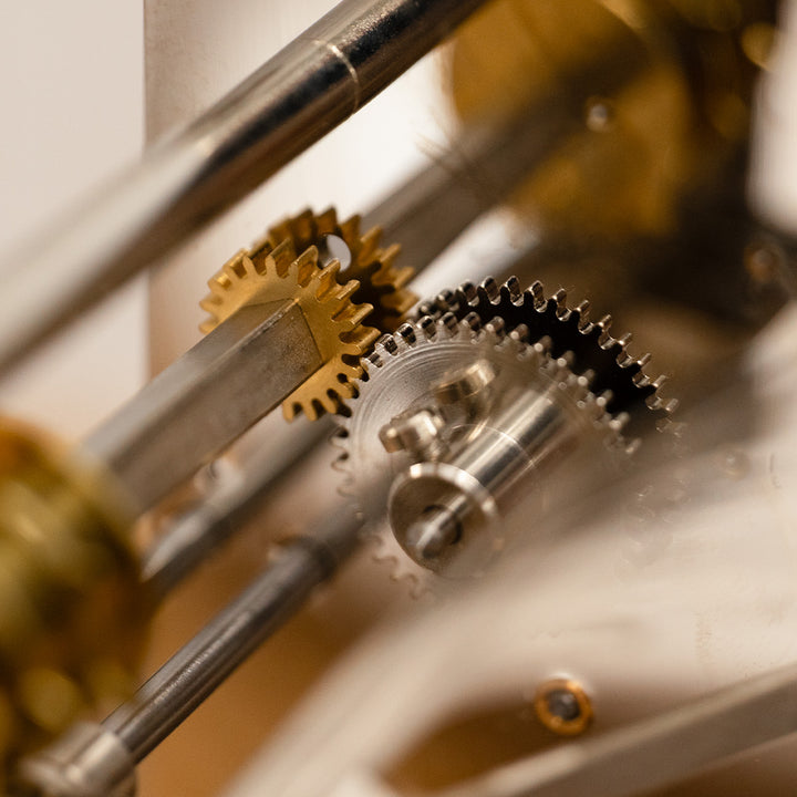Close up of nickel and brass meshed gears in mechanical clock.