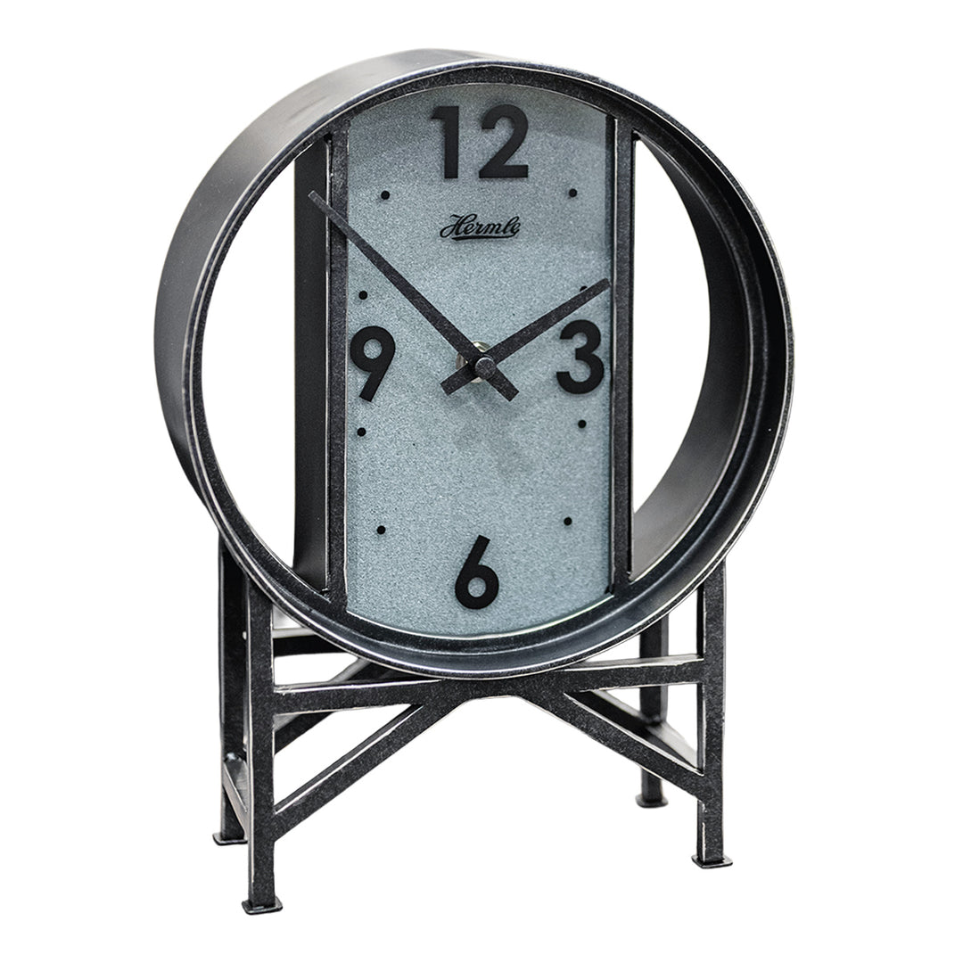 Black metal clock with framework legs and large numbers on white background.