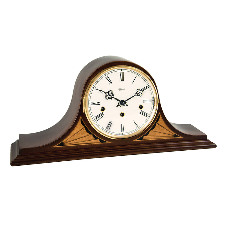 Vintage style mantel clock with brass ring around the dial and roman numerals on white background.