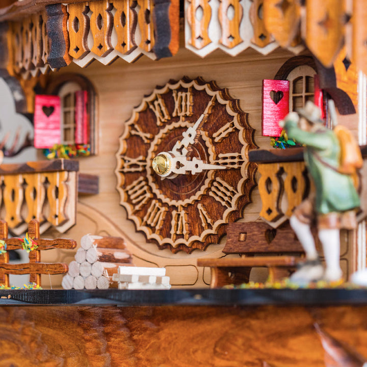 Close up of decorative cuckoo clock face with wooden carved numbers 