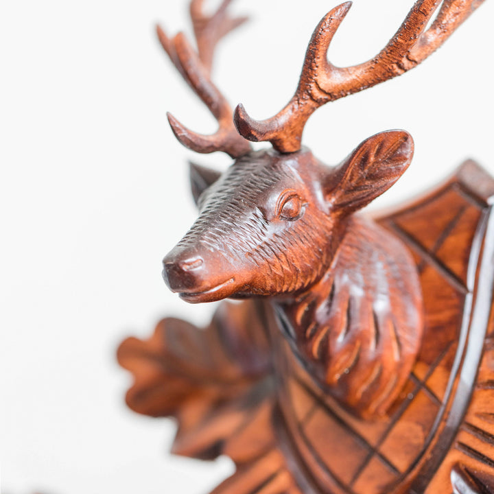 Close-up of carved wooden deer head mounted on top of cuckoo clock