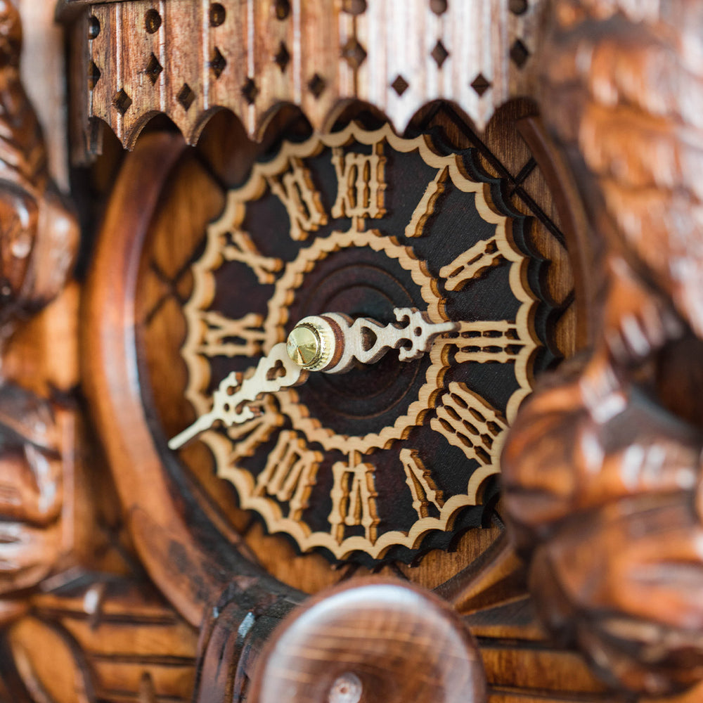 Close-up of a wooden cuckoo clock with detailed face.