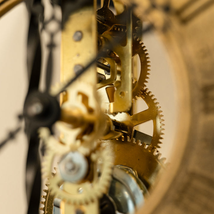 Close up of brass gears inside an antique-style skeleton clock.