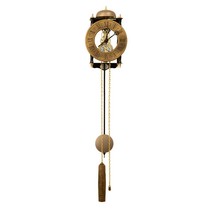 Black skeleton clock with antique-style brass face and etched roman numerals on white background with brass chains and single weight hanging down.