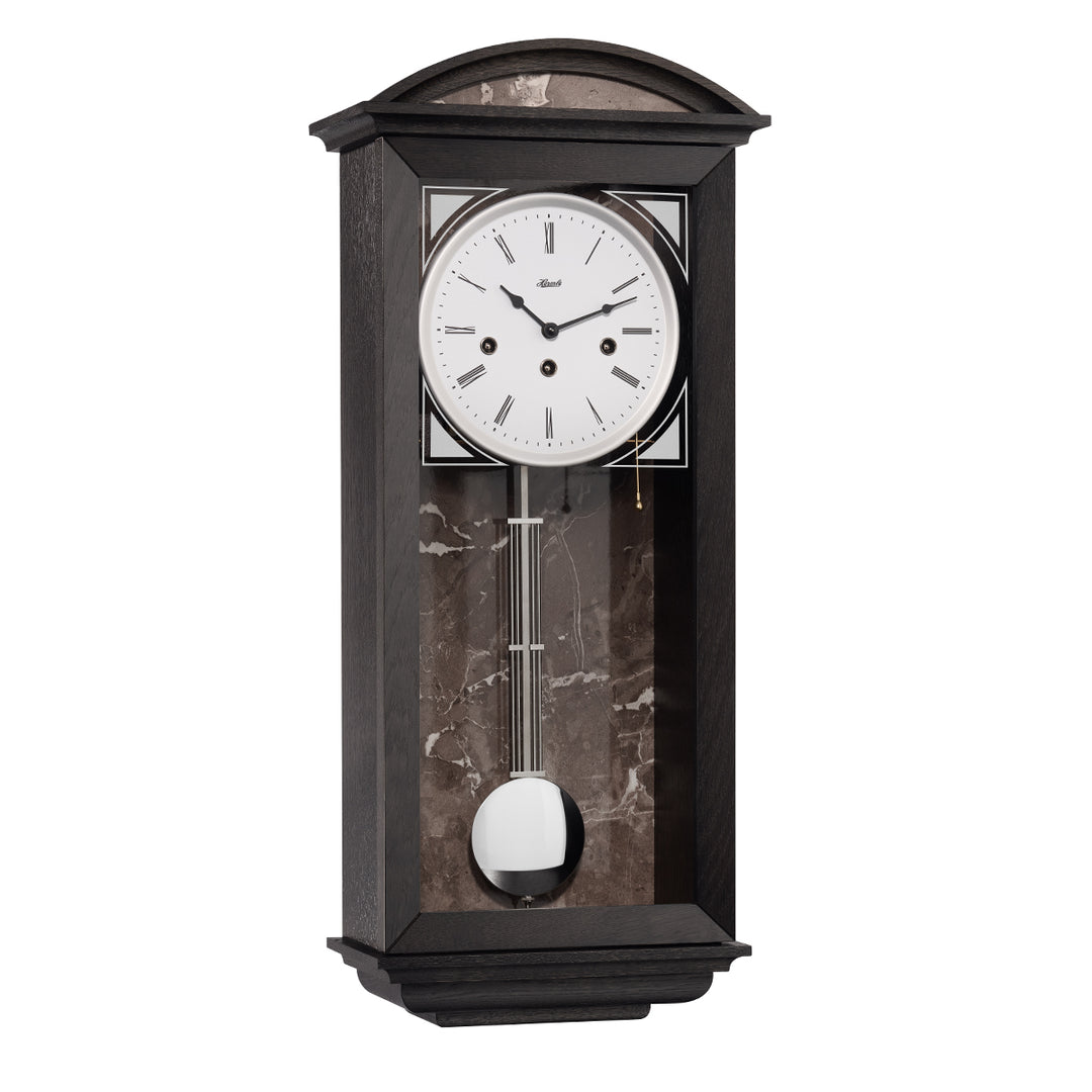 Retro style black wood wall clock with nickel highlights and three holes in the face for winding the mechanical movement inside.