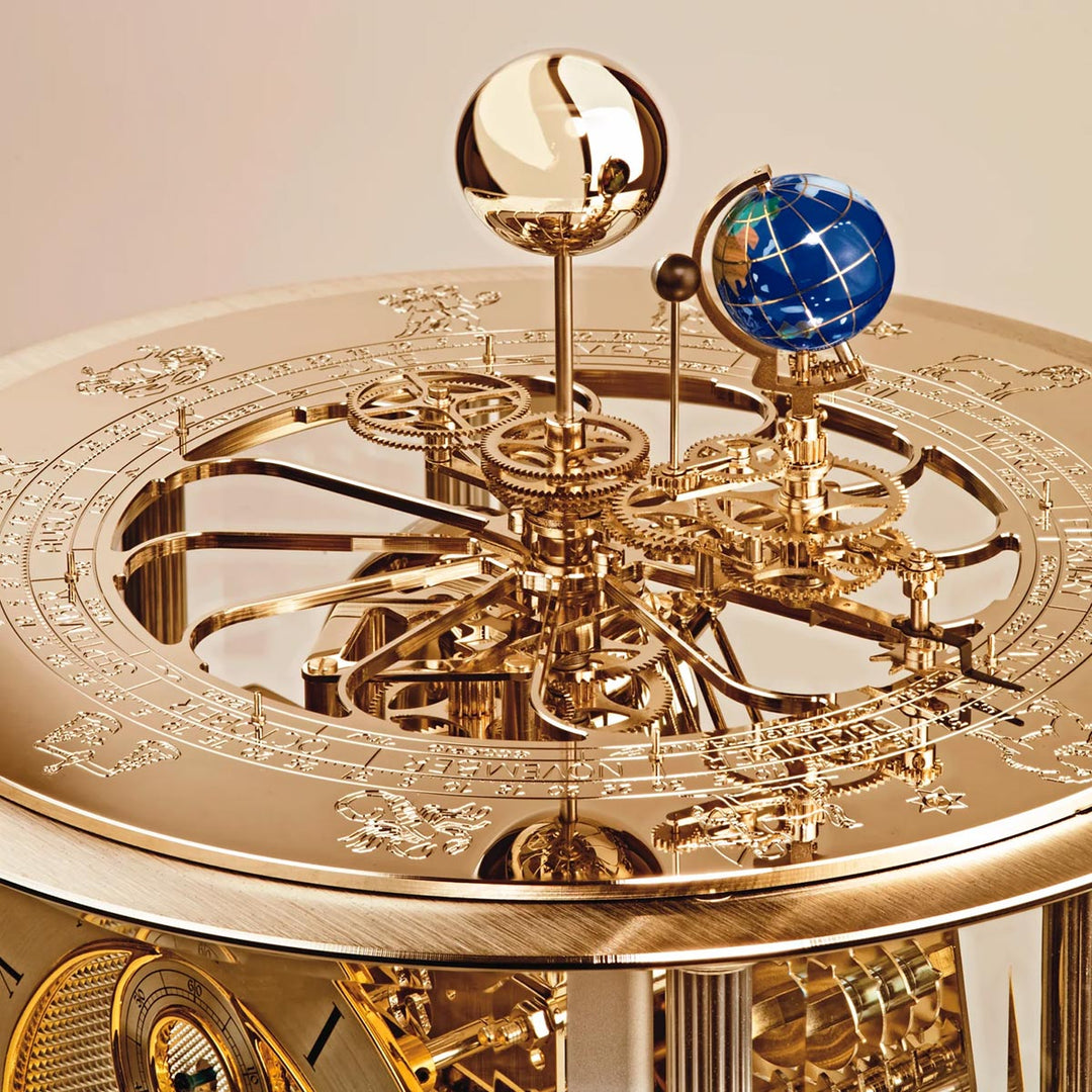 Brass mechanical clock gears with intricate design and globe on a beige background.