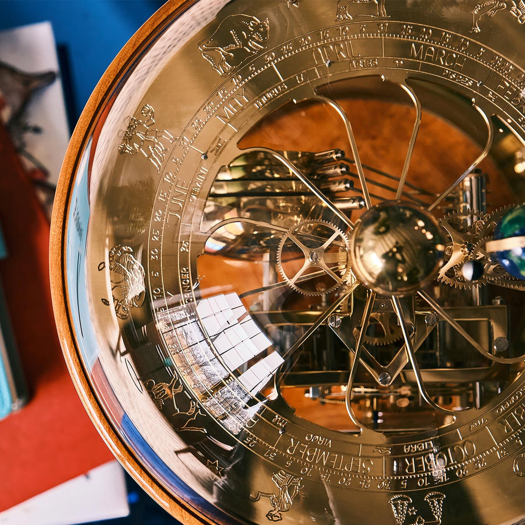 Top down view of brass and cherry woord Tellurium with visible gears and month dial 