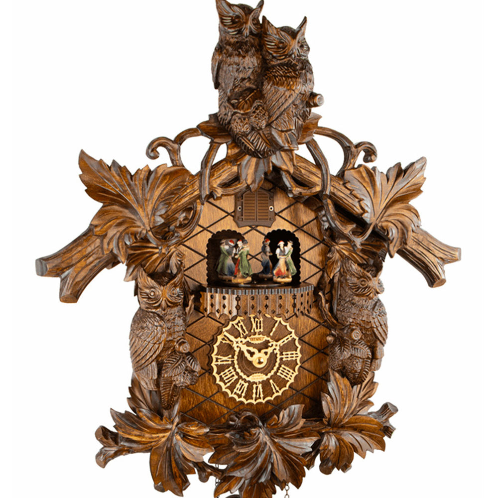 Close-up of owl themed wooden cuckoo clock on white background