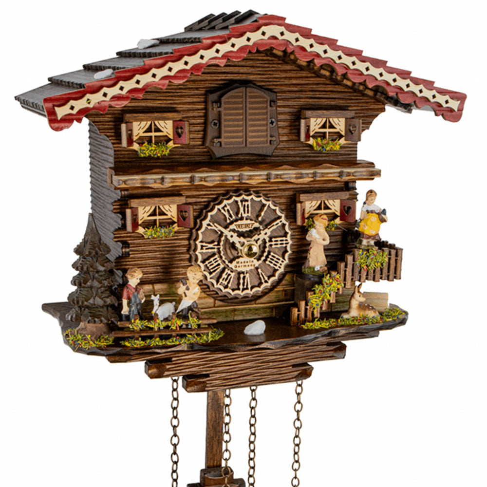 Close-up of cabin and family themed cuckoo clock on white background.