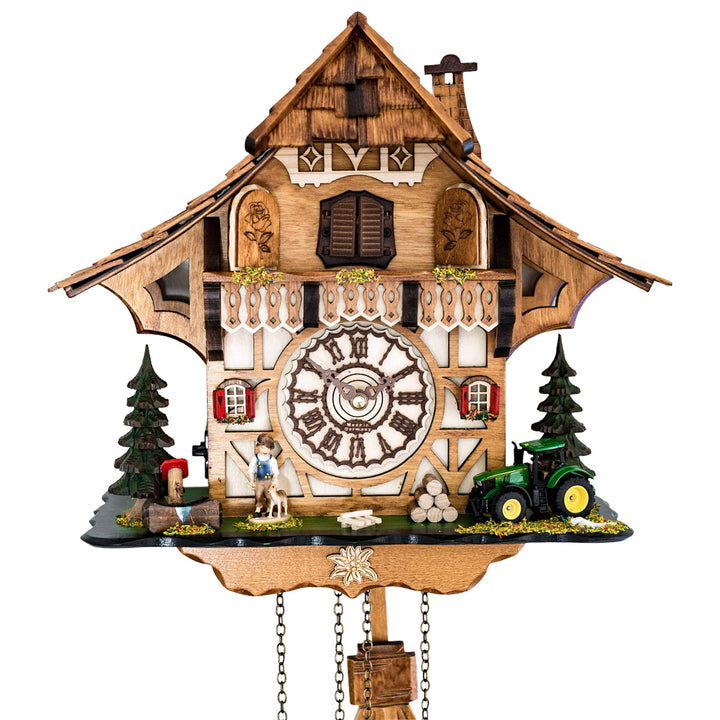 Up close of detailed cuckoo clock with roman numeral face, tractor and boy figure 