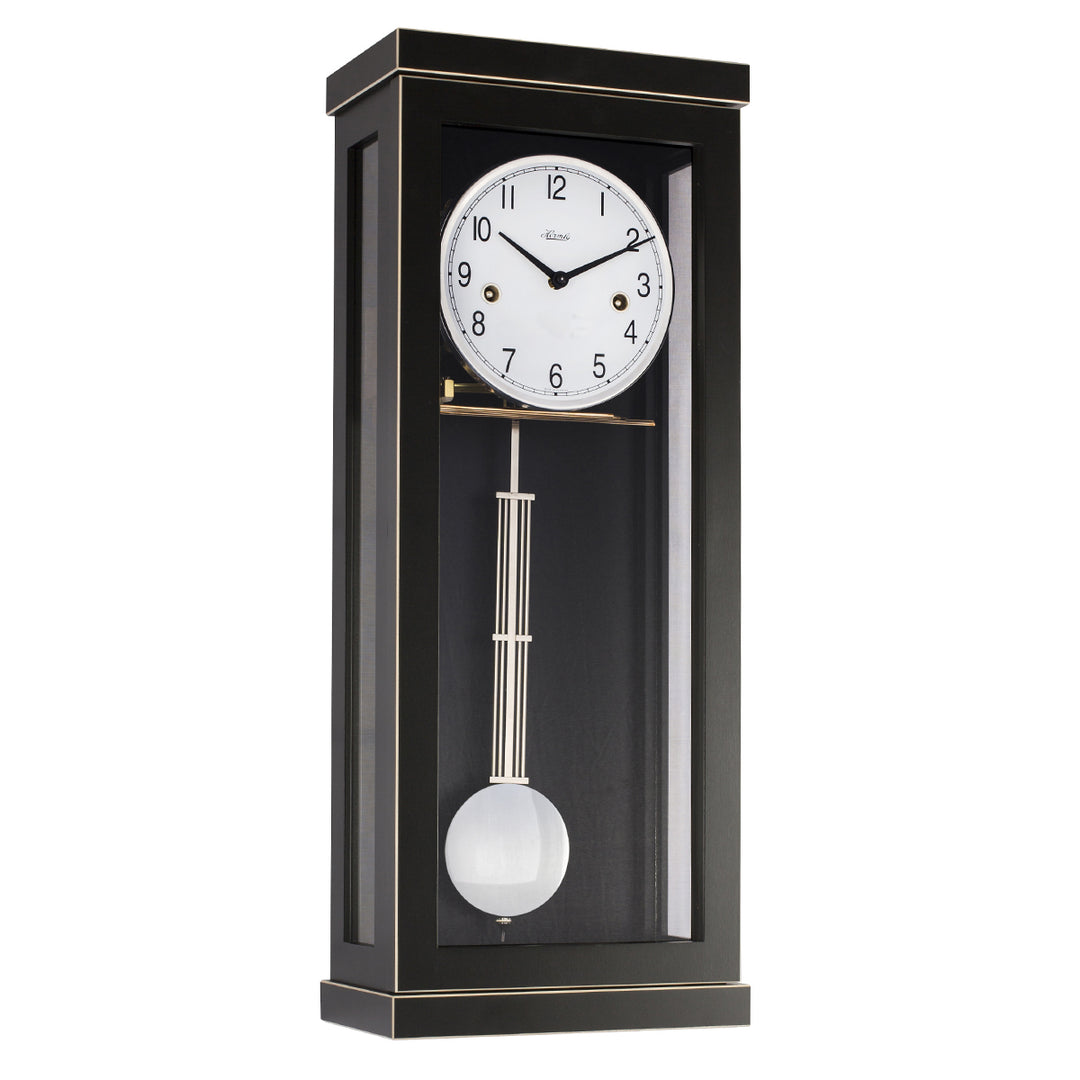 Black wall clock with pendulum on a white background