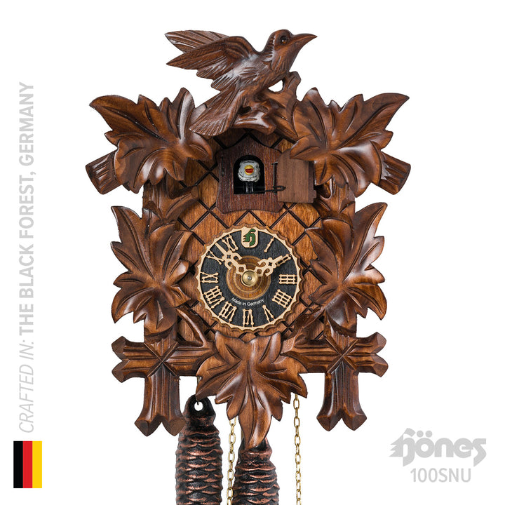German wooden cuckoo clock with bird and leaves by Hones on white background.